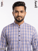 Man wearing a blue and white checkered shirt with a brand logo on the sleeve.